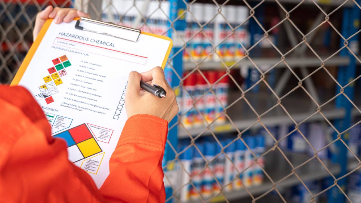 Worker checking to properly label and store hazardous waste.