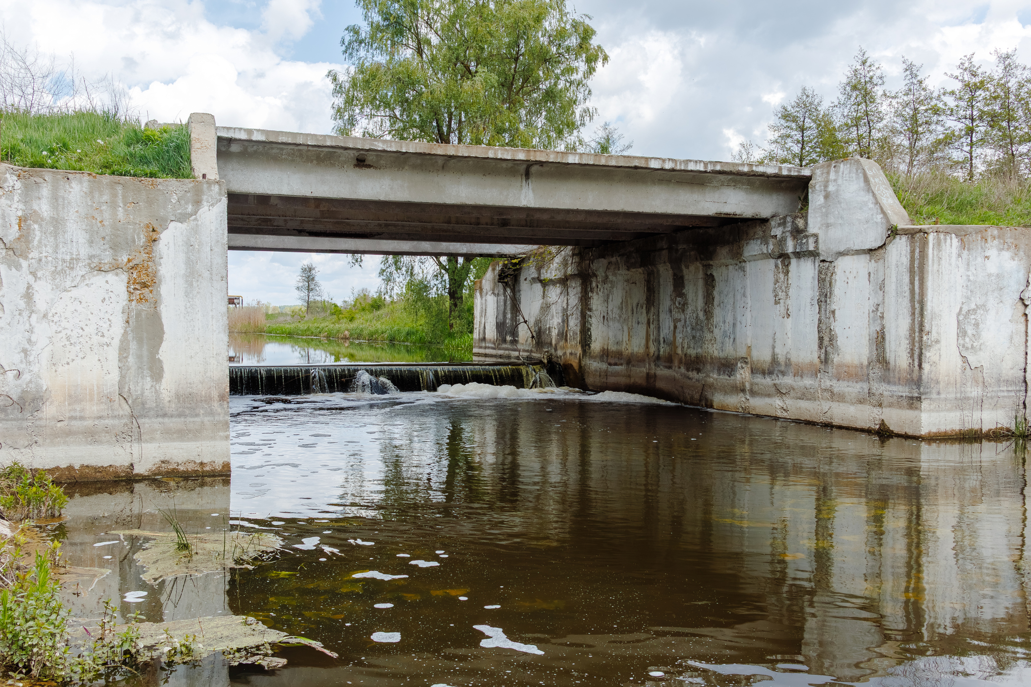 Concrete flood control bridge over river with weir